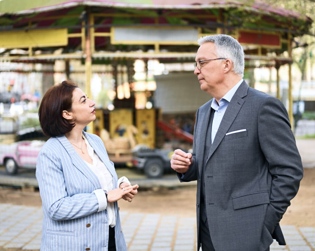 Isolina BOUDI et Lionel GUÉRIN, consultants en recrutement Learn2Fly RH, discutent en extérieur lors d'un échange informel avec un candidat.